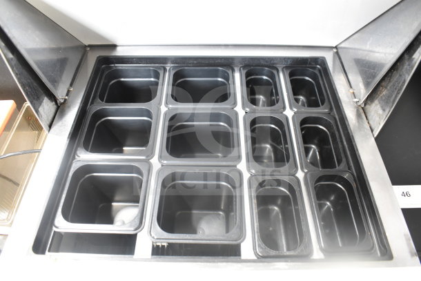 True TSSU-27-12M-B prep table showing multiple plastic food pans in clean condition, with partially open lid.