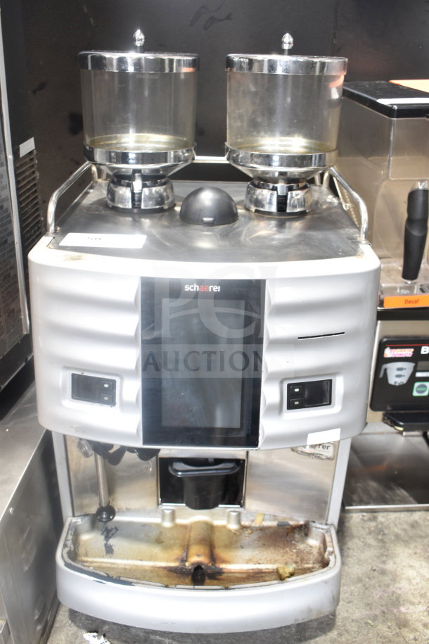 Schaerer Coffee Art Espresso Machine with dual bean hoppers, touchscreen display, and visible wear. Model designed for commercial use.