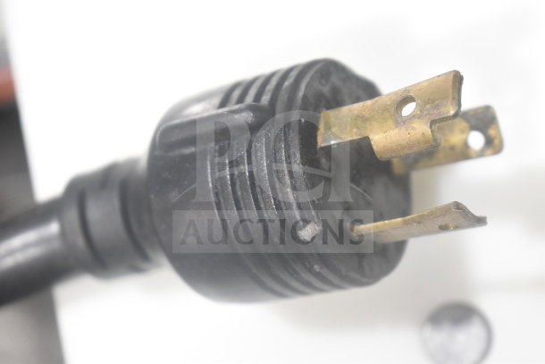 Close-up of a power plug from a Schaerer Coffee Art Espresso Machine, showing wear and tarnish on the prongs.