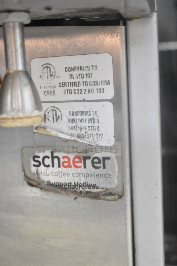 Schaerer Coffee Art Espresso Machine with certification labels visible; stainless steel body showing wear.