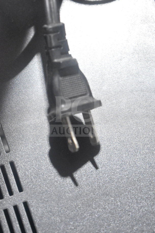 Close-up of a Sony CD player's power cord plug, showing a standard two-prong design on a metallic surface.