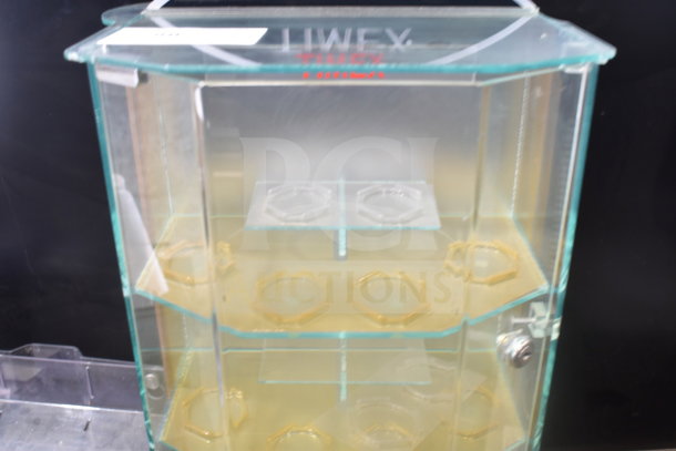 Glass display rack with three shelves, hexagonal holders, and a clear "IWEX" label on top. Condition is good.