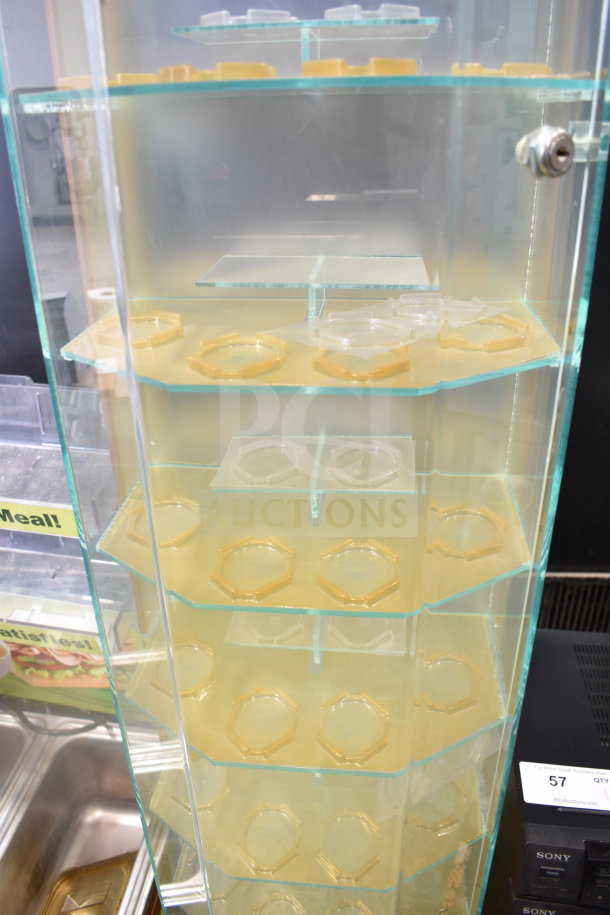 Glass display rack with multiple hexagonal shelves, transparent panels, and a lock. Used for retail showcase.