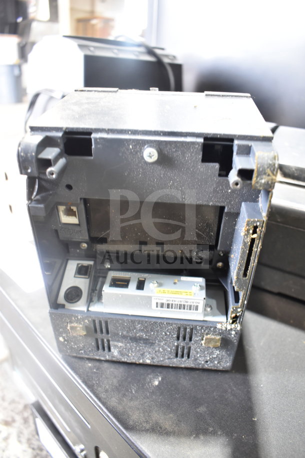 Auction lot with 4 cash drawers and 3 Epson receipt printers. Shows a close-up of printer connections, dusty condition.