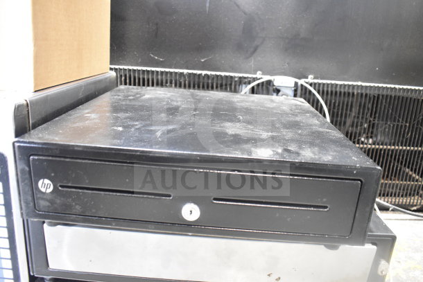 HP cash drawer, black, pre-owned condition with slight surface wear. Part of auction including 4 cash drawers and 3 Epson receipt printers.