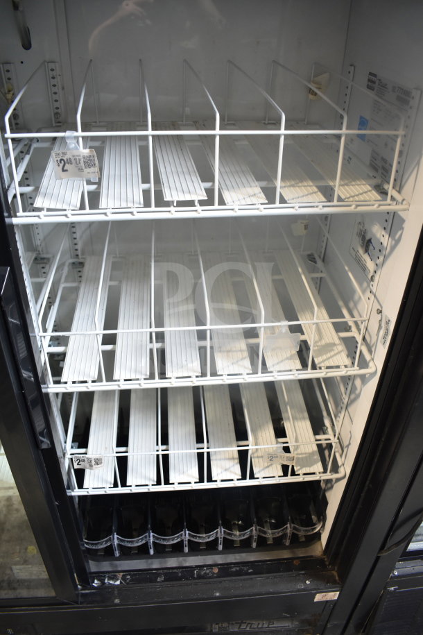 True GDM-41SL-60EM-LD commercial 2-door cooler, white shelving, price tag visible, 115V, 1 Phase, used condition.