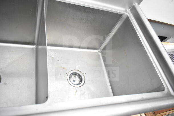 Commercial 3 bay stainless steel sink with faucet and handles, in good condition, visible surfaces clean and intact.