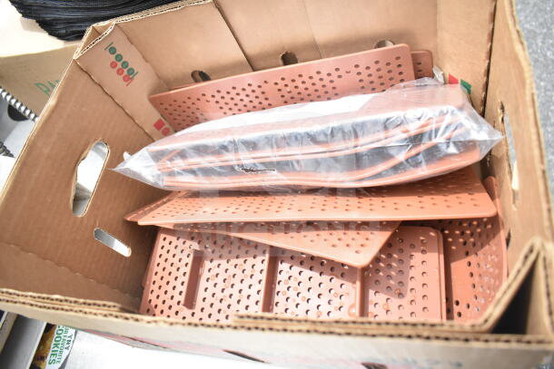 Cardboard box containing Duke Subway sandwich make line piece with perforated baking pan liners.