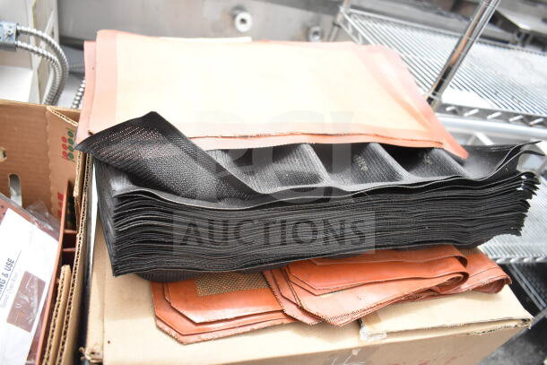 Duke Subway sandwich make line piece with multiple baking pan liners, stacked on a cardboard box, in used condition.