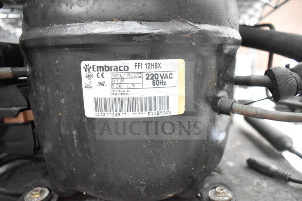 Embraco FFI 12HBX Compressor, 220V, 60Hz. Thermally protected. Made in Brazil. Labels indicate model and protection.