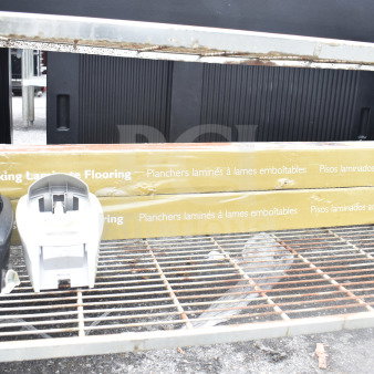 Four items include black and white soap dispensers and two boxes of laminate flooring with packaging text. Items on metal rack.