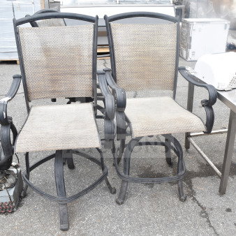 Three outdoor armchairs with metal frames and mesh seats. Slightly weathered condition. Ideal for patio use.