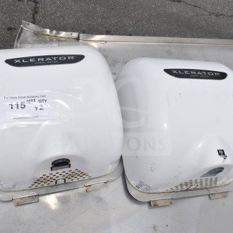 Two Xlerator hand dryers in used condition, white, labels indicating model and auction details visible.