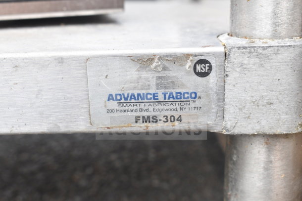 Commercial table with sink bay, over shelf, and under shelf by Advance Tabco, Model FMS-304. Visible wear on metal.