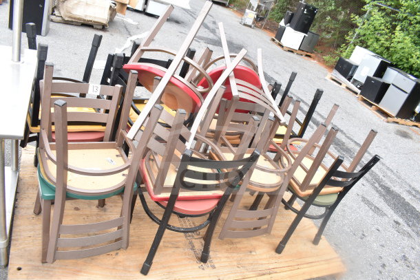 18 assorted dining chairs, stacked on a pallet, various colors, mixed materials, fair condition, auction lot.