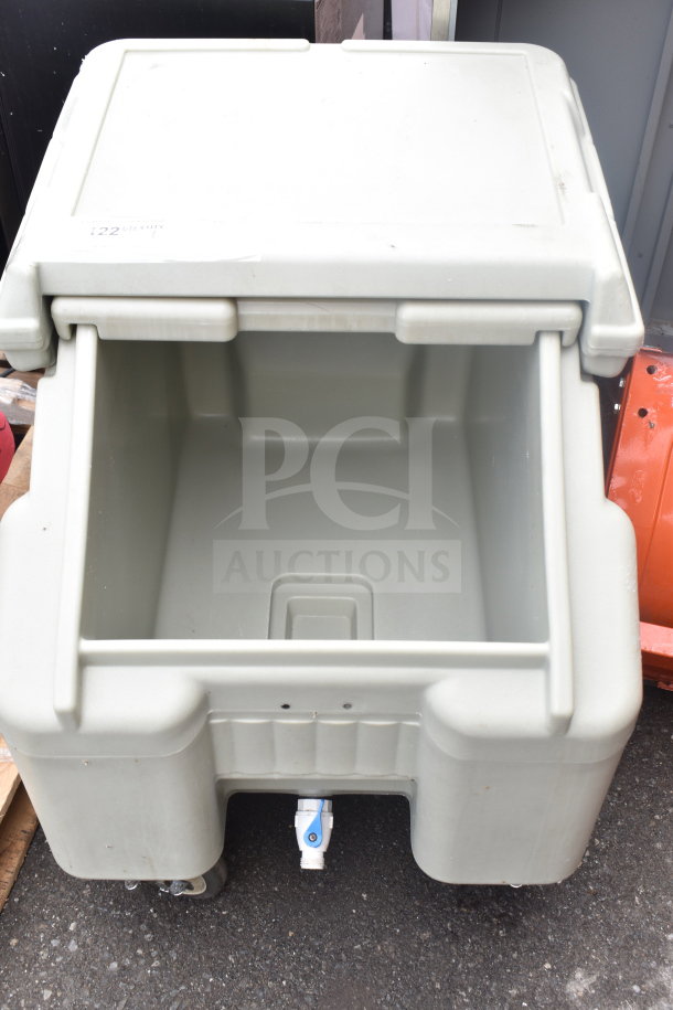 Poly portable ice bin on commercial casters, no lid. Features drainage spout. Light wear, good condition for auctions.