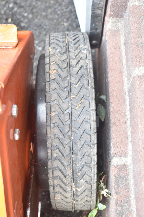 Agri-Fab lawn mower brushing attachment with robust wheel tread detail, showing slight wear and minimal debris.