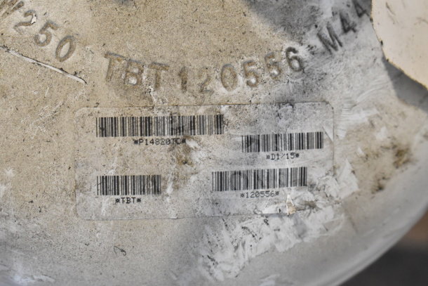 Worn fire suppression tank with visible barcodes and markings including "TBT120556" and "*P14820TC*" on surface.