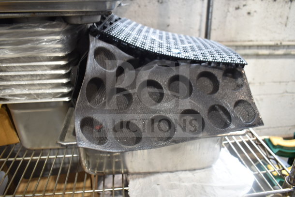Tier lot with various items including stacks of drop-in bins, pan liners, and perforated baking mats. Used condition.