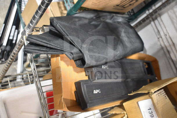 Tier lot of various items including black drop-in bins and APC-labeled components in a warehouse setting.