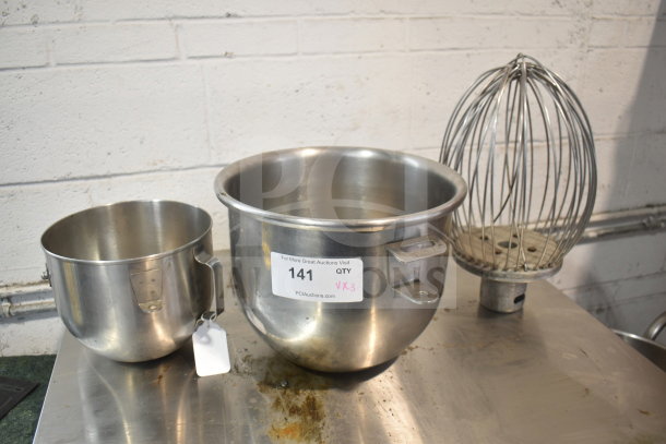Three mixer items: two stainless steel mixing bowls and a wire whisk attachment. Includes condition label with lot number 141.