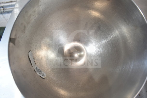 Stainless steel mixing bowl with visible use marks and a label inside. Suitable as a mixer attachment.