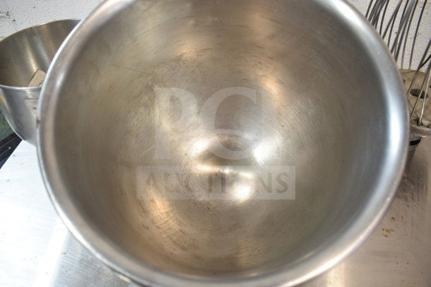 3 stainless steel mixer items: 2 mixing bowls and a whisk attachment. Used condition with visible wear.
