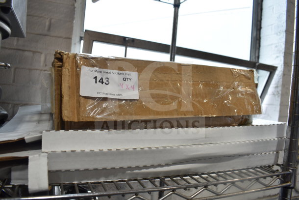 Cardboard box with label "143 QTY XX4," contains various items including Lavex 17" green scrubbing pads and Norton Q421 floor screen discs.