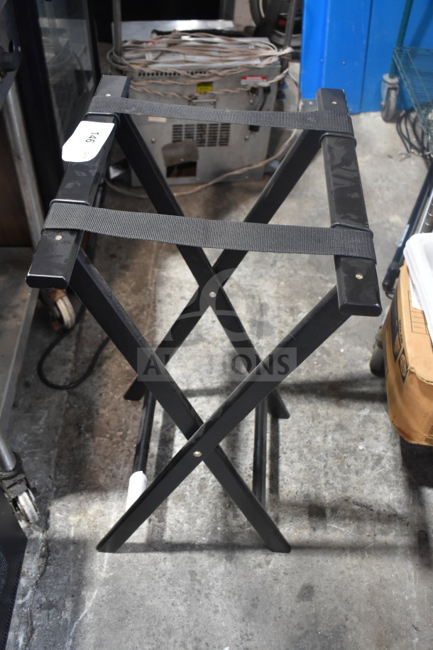 Black metal serving tray stand with crisscross design and black straps. Label on side reads "146." In good condition.