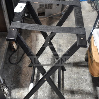 Black metal serving tray stand with crisscross design and black straps. Label on side reads "146." In good condition.