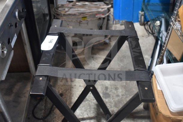Black folding serving tray stand with sturdy black straps, slightly worn. Tag marked "146."