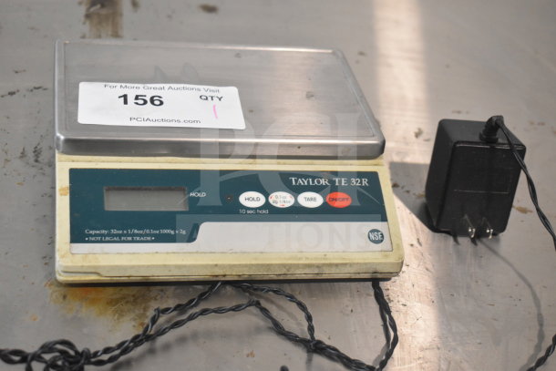 Taylor TE32R countertop scale, stainless steel platform, shows wear. Capacity 32oz/1000g. Includes power adapter.
