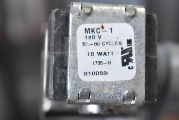 Label on a metal part reading "MKC-1, 120V, 50-60 Cycles, 10 Watt, 1708-H, 610000." Indicates power specifications.