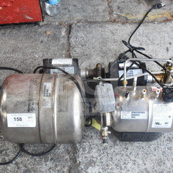 Stainless steel carbonators set, auction lot 158, with visible warning labels and wiring, in used condition.