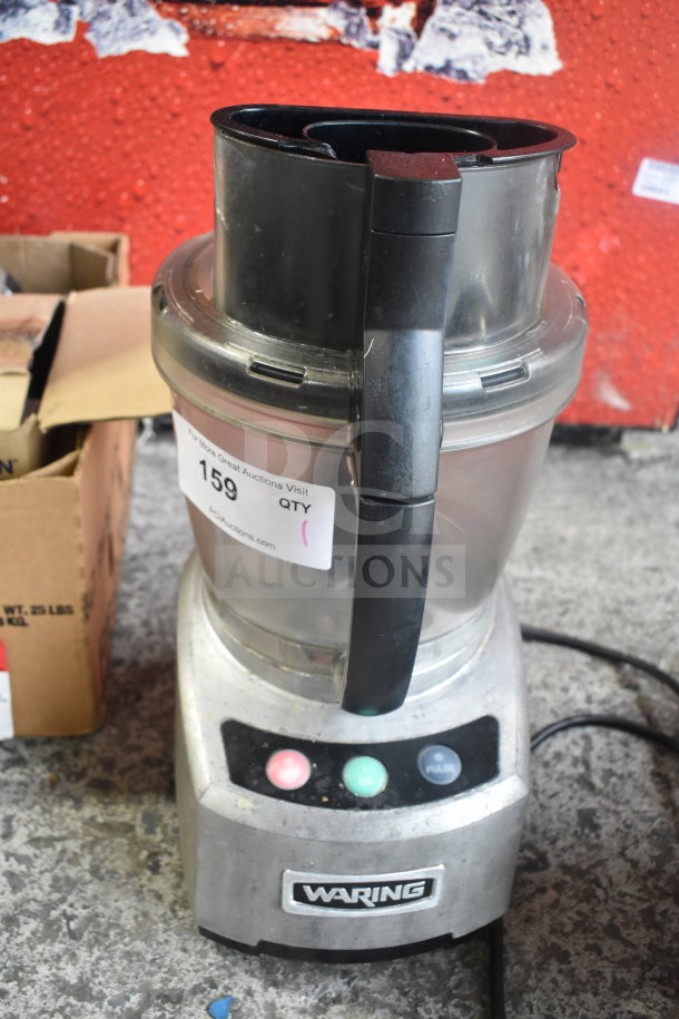 Waring countertop food processor, 115 volts, 1 phase, showing buttons and handling grip. Good condition. Auction tag visible.