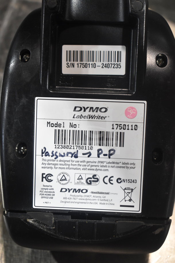 Dymo LabelWriter label with model number 1750110, serial number, and FCC compliance details on black surface.