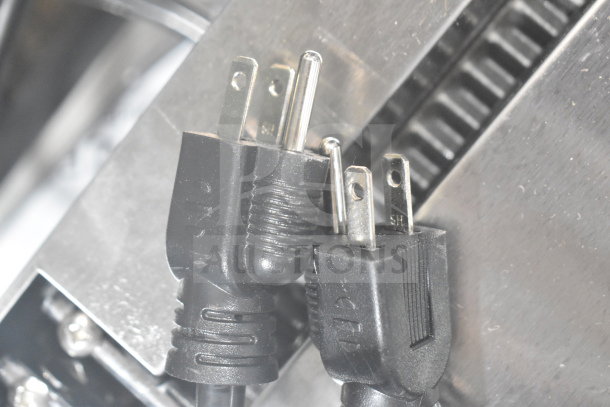 Close-up of dual electrical plugs for Avantco 177PG400T Panini Grill, shown against a metallic surface.
