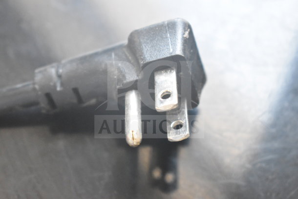 Close-up of a black power plug for the Aquaverse A6500 water dispenser, showing a three-prong design.