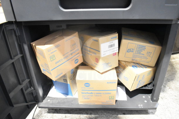 Konica Minolta Bizhub C3350 printer base with multiple toner cartridge boxes visible inside. Boxes marked for C3350/C3850.
