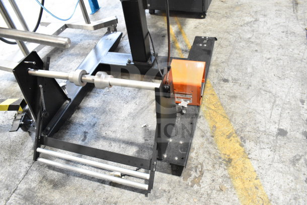 Advanced Poly Packaging T-1000 bagger, black and orange, 117/220V, in good condition, showing mechanical base and rollers.