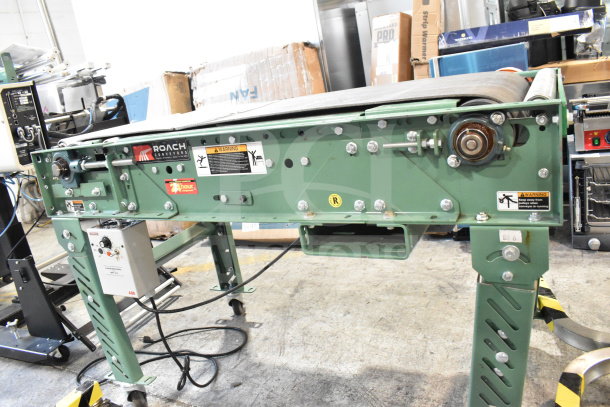 Roach floor style conveyor, green, 115 volts, 1 phase. Features include adjustable legs, safety labels, and control panel.