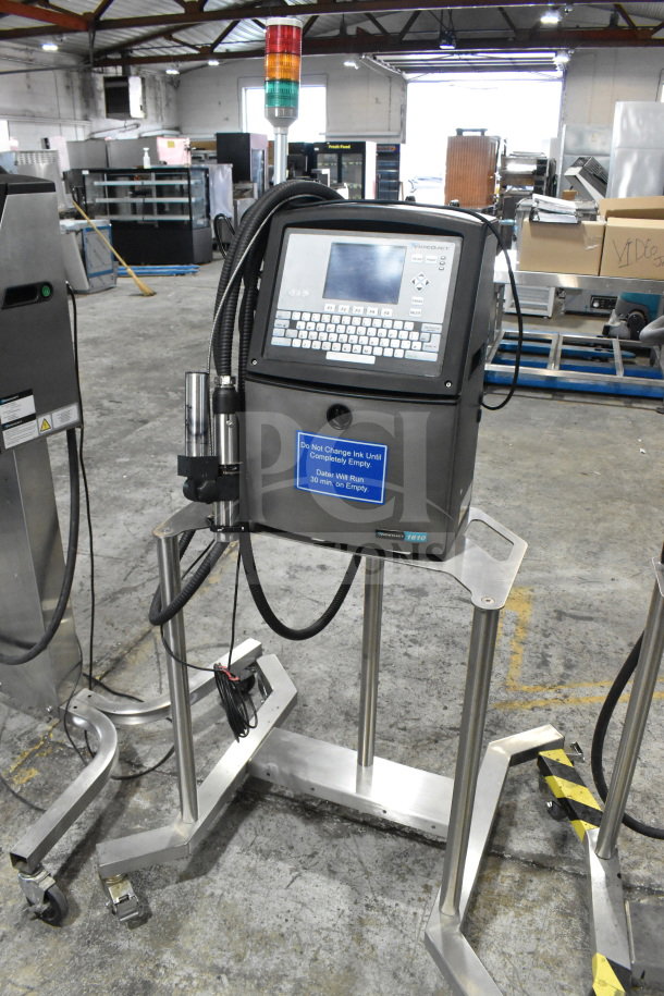 Videojet 1610 inkjet coding machine on stand, 100-240V, 1 phase; features display screen, control panel, caution label.