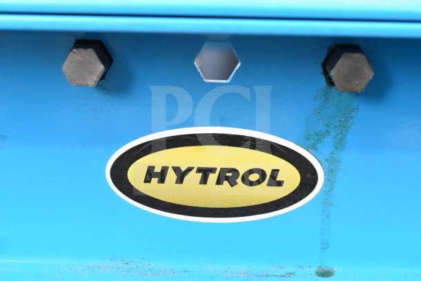Hytrol Floor Style Roller Conveyor, blue frame, features hex bolts. Black and yellow Hytrol label on the side.