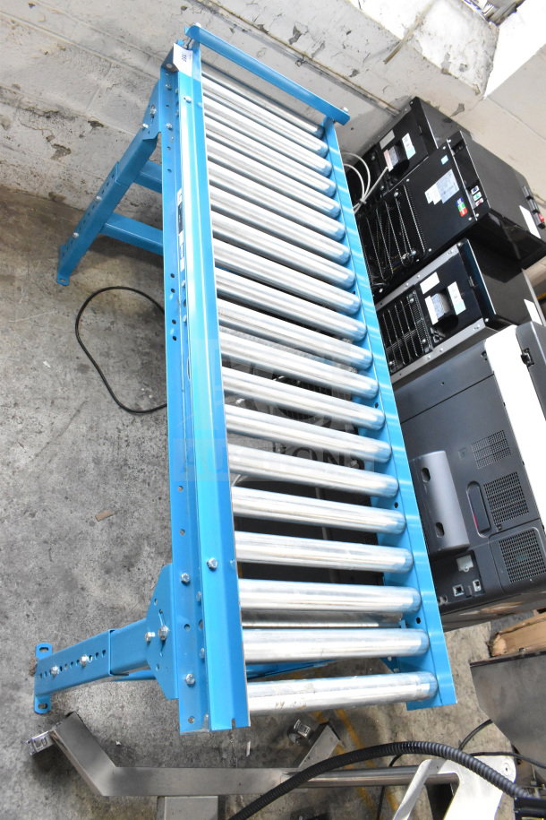 Hytrol Floor Style Roller Conveyor in good condition, with blue frame and metallic rollers. Ideal for material handling.