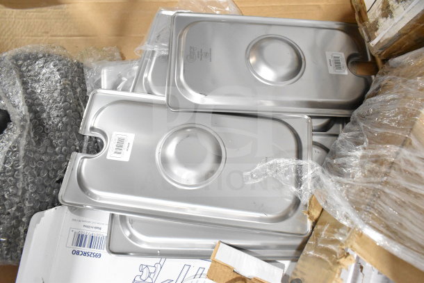 Various stainless steel drop-in bin lids with product labels, packed in a cardboard box with bubble wrap.