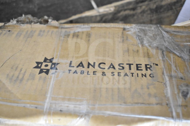 Cardboard box labeled "Lancaster Table & Seating," containing various items for auction. Items include Crathco hoppers, coffee filters, bin lids, dinner knives, exit signs, and sheet pans. Box slightly worn.