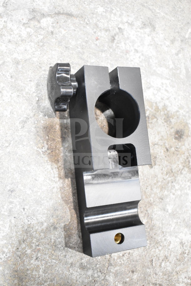 Black metal bracket with adjustable knob, circular opening, and a lower mount, in good condition.