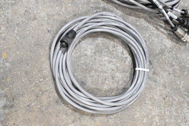 Coiled gray 25-way I/O breakout cable on concrete floor, labeled "CAROL" and "MADE IN USA". Clean, in good condition.