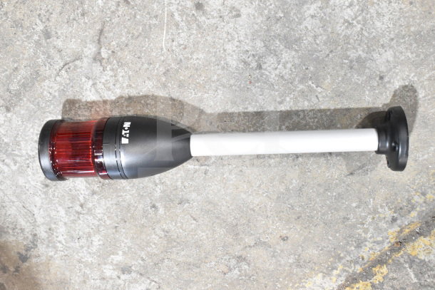 Eaton wash station kit with red lens, black and white handle, labeled "Eaton," on concrete floor.