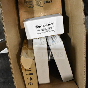 Box containing various VideoJet items including head photo and label sensor, packaged and ready for auction.